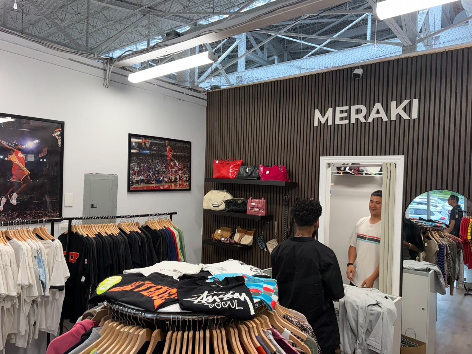 Inside Meraki Vintage — designer bags and racks under the MERAKI wall sign